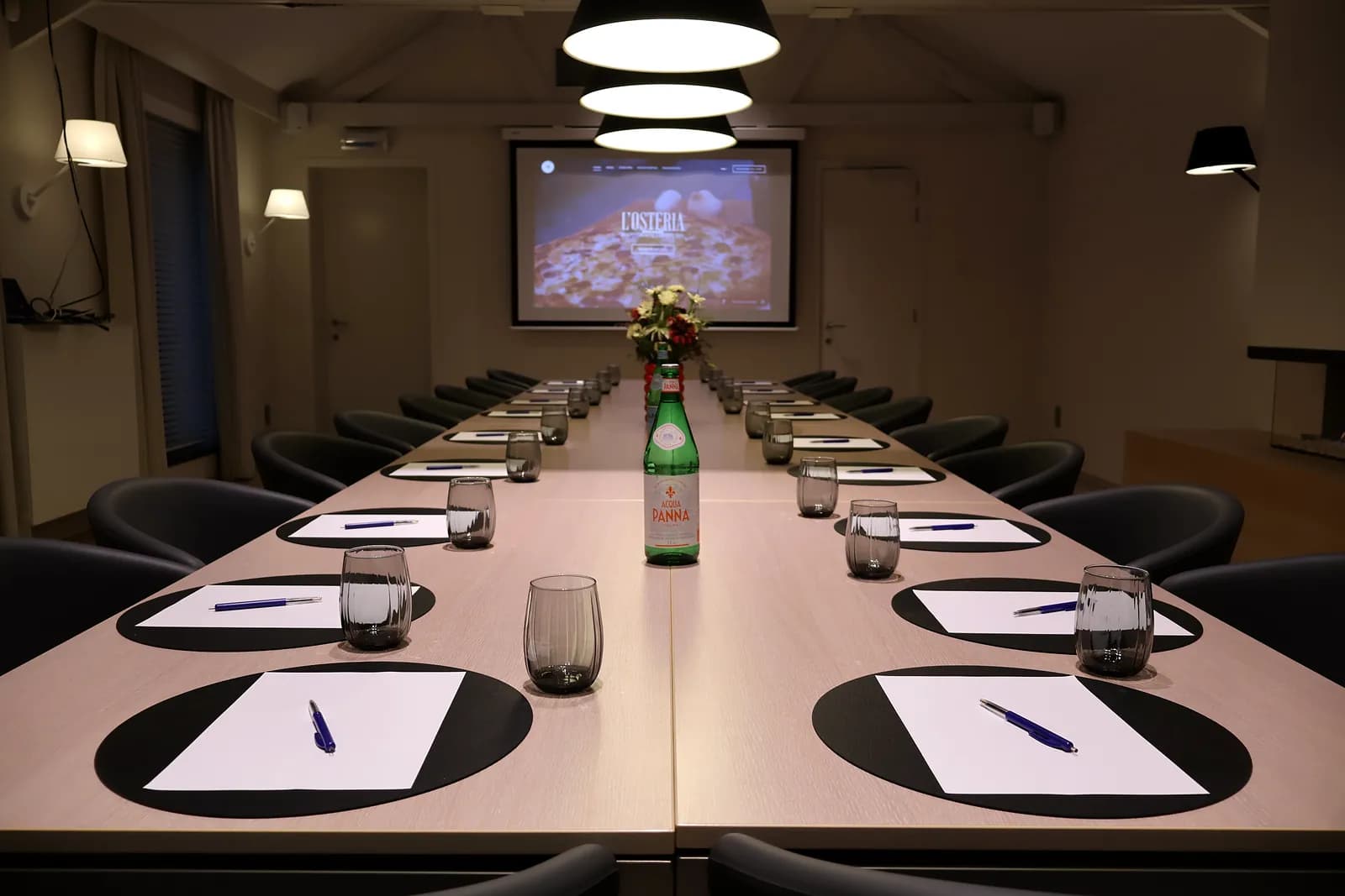 Meeting table set with notepads, pens and water